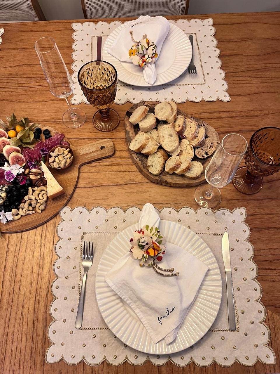 Mesa posta com louças brancas e sousplats