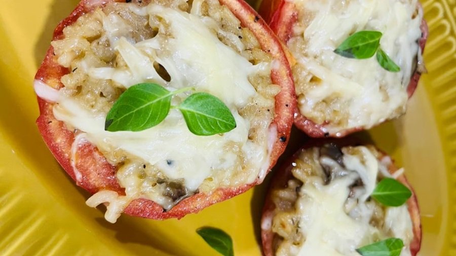 Tomate recheado com risoto de cogumelos servido em prato amarelo