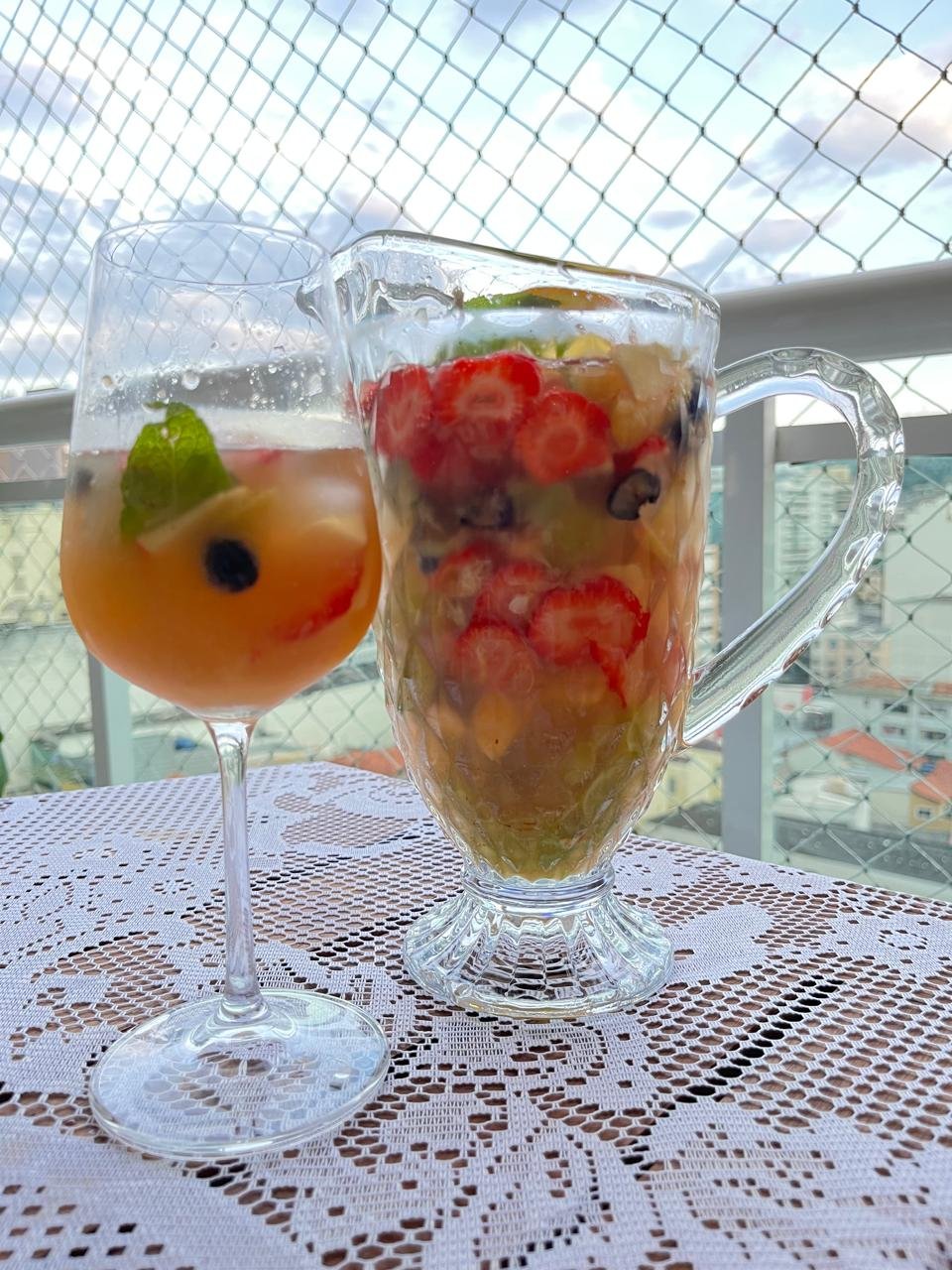 Taça e jarra de clericot em mesa leve de verão